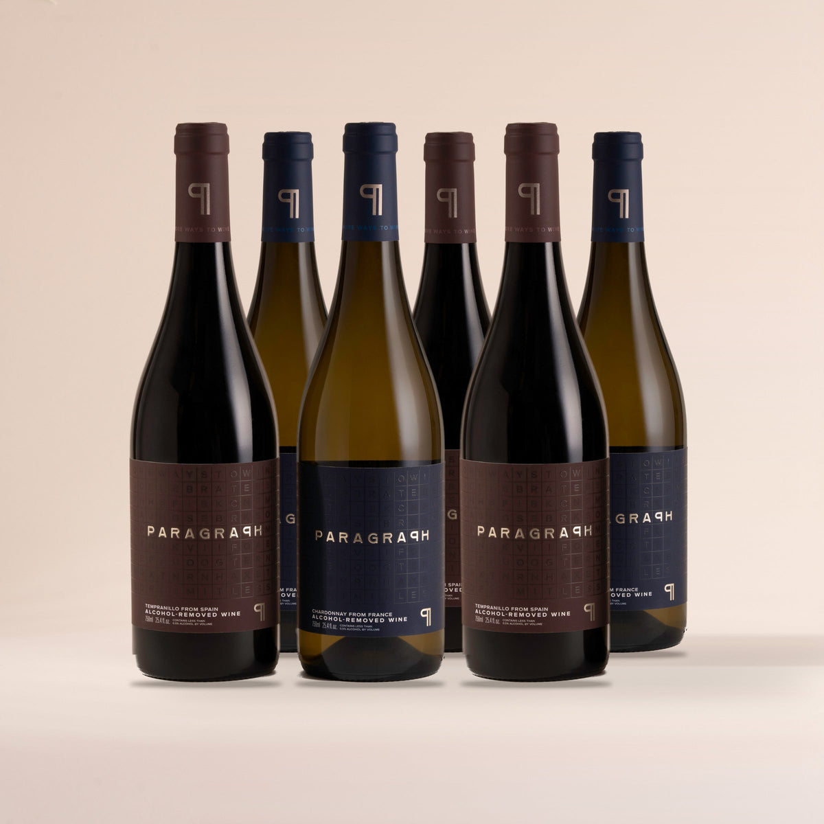 Three bottles of PARAGRAPH Tempranillo and three bottles of PARAGRAPH Chardonnay, standing on cream